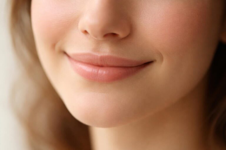 Close-up do rosto de uma pessoa com um sorriso sutil e gentil.